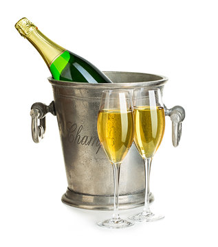 Champagne bottle in ice bucket with glasses of champagne close-up isolated on a white background. Festive still life.