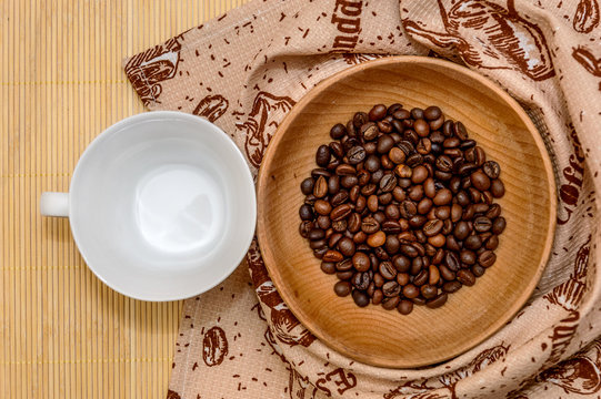 White cup and a wooden bowl with coffee beans © igorkol_ter