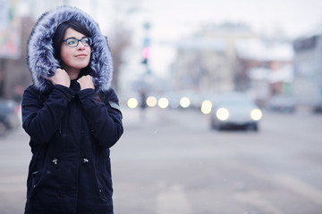 snowy winter portrait of a girl in the city on the road