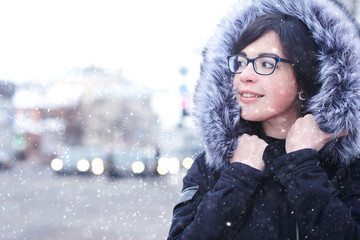 snowy winter portrait of a girl in the city on the road