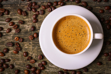 hot cup of coffee and coffee beans on the old wooden table