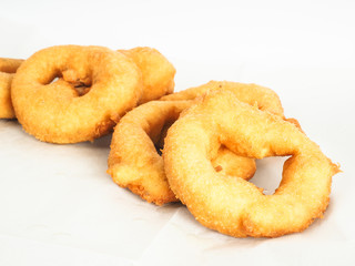 Closeup of doughnuts in pile on baking paper