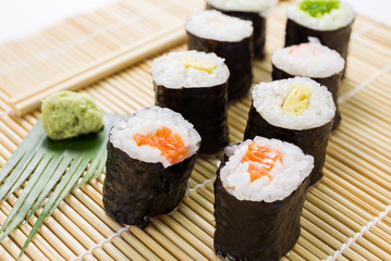 Salmon, egg and vegetable sushi rolls with sauce and wasabi