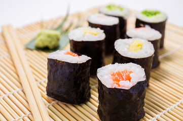 Salmon, egg and vegetable sushi rolls with sauce and wasabi