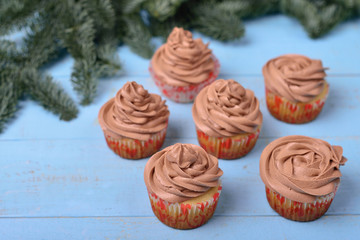 cupcakes with chocolate cream on a blue wooden background