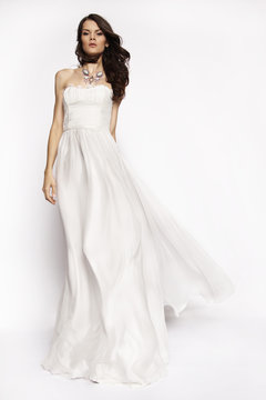 Brunette in white dress posing
