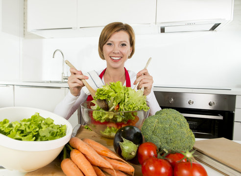 young beautiful home cook woman at modern kitchen preparing vegetable salad bowl smiling happy