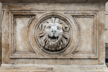 Fototapeta na wymiar Column base with lion's head carved in stone
