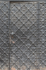 old iron door with handle reinforced with steel belts and rivets