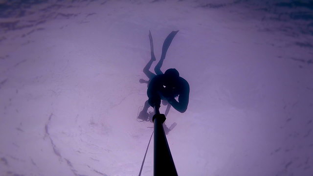 Freediver in silhouette reaching a depth of 20m of 60 feet in 30 seconds.