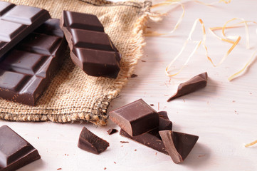 Broken tablet artisan chocolate on wooden table elevated view