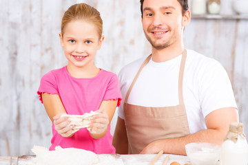 Happy father and daughter baking together 