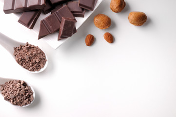 Portions and chocolate chips on container with almonds isolated