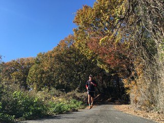 Runner on country road with autumn leaves