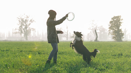 Young woman playing with her border collie dog