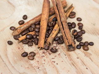 chocolate, cinamon and coffee beans on wooden table.