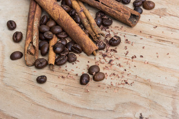 chocolate, cinamon and coffee beans on wooden table.