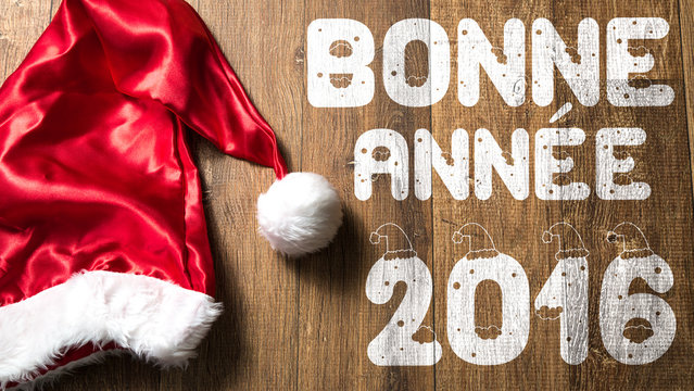 Happy New Year (in French) written on wooden with Santa Hat