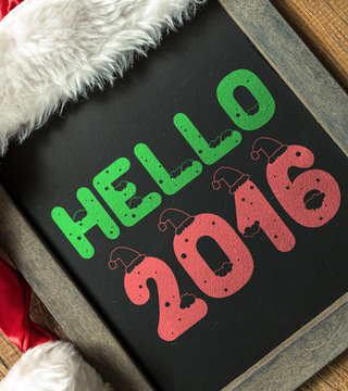 Hello 2016 written on blackboard with santa hat