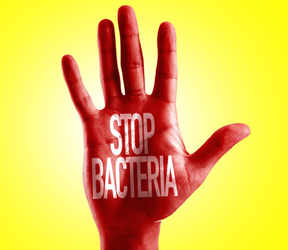 Stop Bacteria written on hand with yellow background