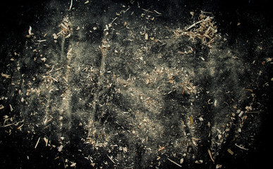 Explosion of sawdust on black background. - obrazy, fototapety, plakaty