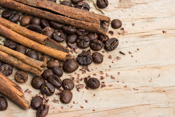 chocolate, cinamon and coffee beans on wooden table.