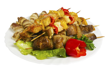 Skewers of chicken, pork, beef, lamb with greens on the plate, isolated