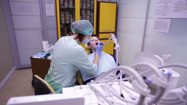 The dentist treats teeth teenager dental drill