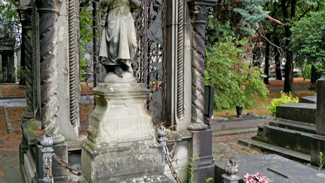 One of the tombstone inside the cemetery in Paris. There is sculpture of a saint on the tomb 