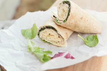 a healthy wrap with turkey, greens and cheese made with whole grain tortilla wrap