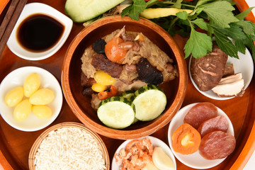 Zongzi and ingredients Ginkgo Biloba, shrimp, mushrooms, onion, garlic, duck egg, sticky rice, sausage, sauce and pepper, pork, deep fried combination wrapped in bamboo leaves and then steamed.