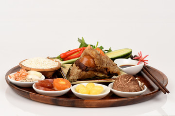 Zongzi and ingredients Ginkgo Biloba, shrimp, mushrooms, onion, garlic, duck egg, sticky rice, sausage, sauce and pepper, pork, deep fried combination wrapped in bamboo leaves and then steamed.