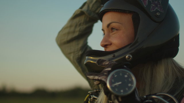 Smiling Girl Skydiver is Taking off the Helmet after Successful Landing. Shot on RED Cinema Camera.