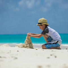 Little child making sand castles at the beach