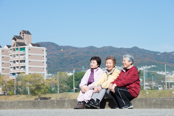 笑顔で座っているシニア女性3人組