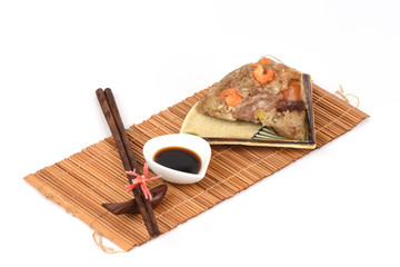 Zongzi and ingredients Ginkgo Biloba, shrimp, mushrooms, onion, garlic, duck egg, sticky rice, sausage, sauce and pepper, pork, deep fried combination wrapped in bamboo leaves and then steamed.