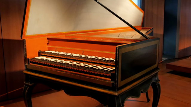 An old grand piano inside a room with yellow light that gives more beauty to the old piano