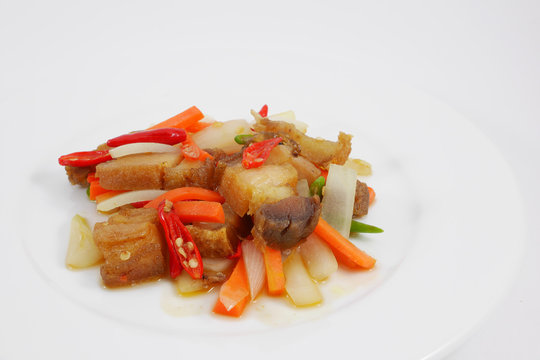 The Thai stir fried crispy pork in the white plate.