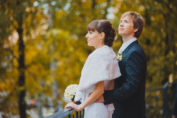 Autumn wedding, the groom embraces the bride