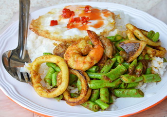 stir-fried curry seafood and fried egg on rice