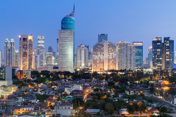 De skyline van het centrum van Jakarta met hoogbouw bij zonsondergang