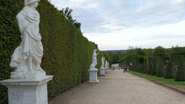 The white statues on the green borders in the castle. Standing infront of the green plant borders in the castle