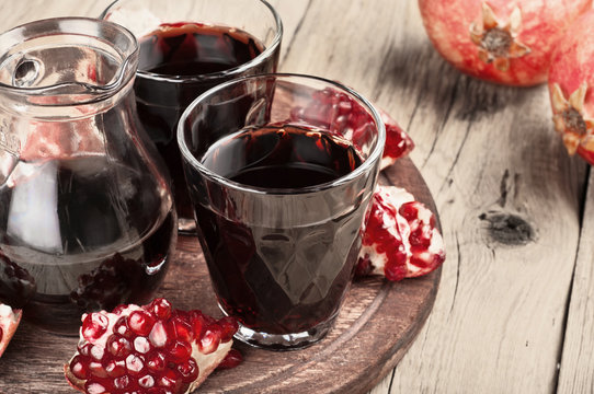 Glass of red pomegranate juice with slices of pomegranate