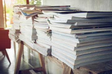 stack of magazine book on wooden table shelf in living room