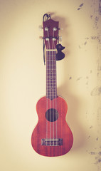 Still life with ukulele Old on the wall,vintage color toned imag