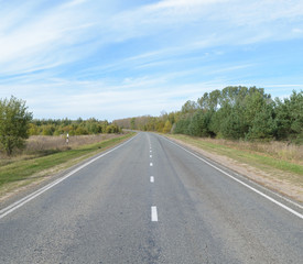 Suburban asphalt highway with white intermittent markings