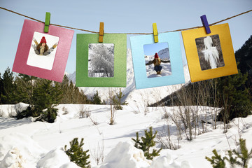 Beautiful winter framed photos with clothespins on a background