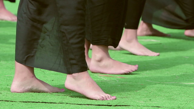 Close up image of hula dancer's feet as they perform on stage