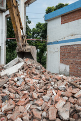 Fototapeta na wymiar excavator demolishing concrete and brick rubble debris vertical