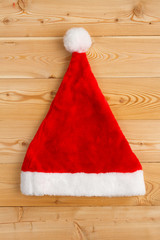 Obraz na płótnie Canvas Red Santa hat on wooden background